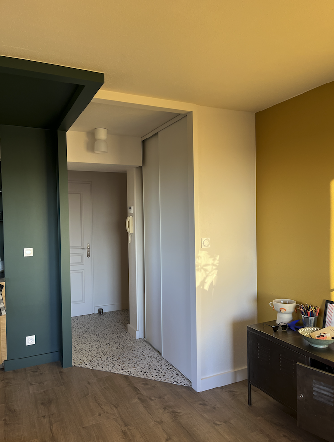 entrée et couloir délimitée avec les couleurs et matières pour avoir un espace chaleureux et personnalisé placard encastré avec porte coulissante