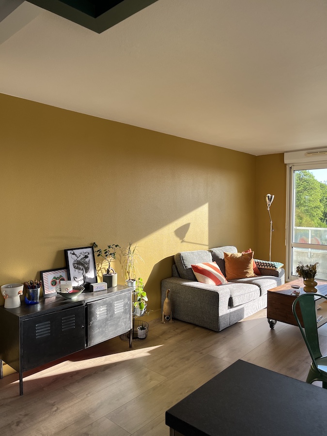 salon baigné de joie avec du jaune ocre et du soleil sur le canapé confortable
